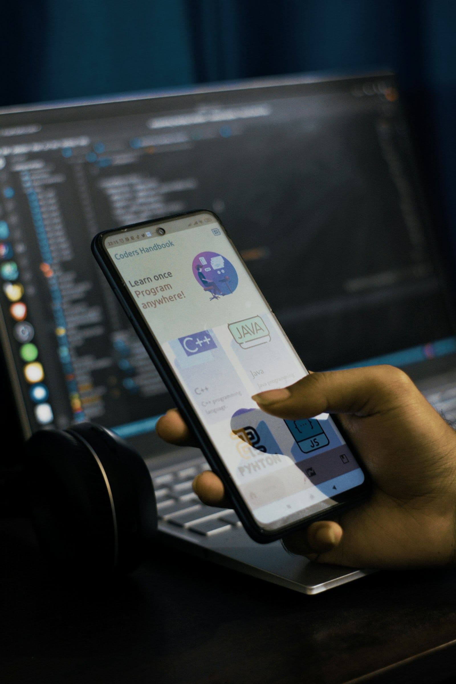 Phone app held in front of a code editor